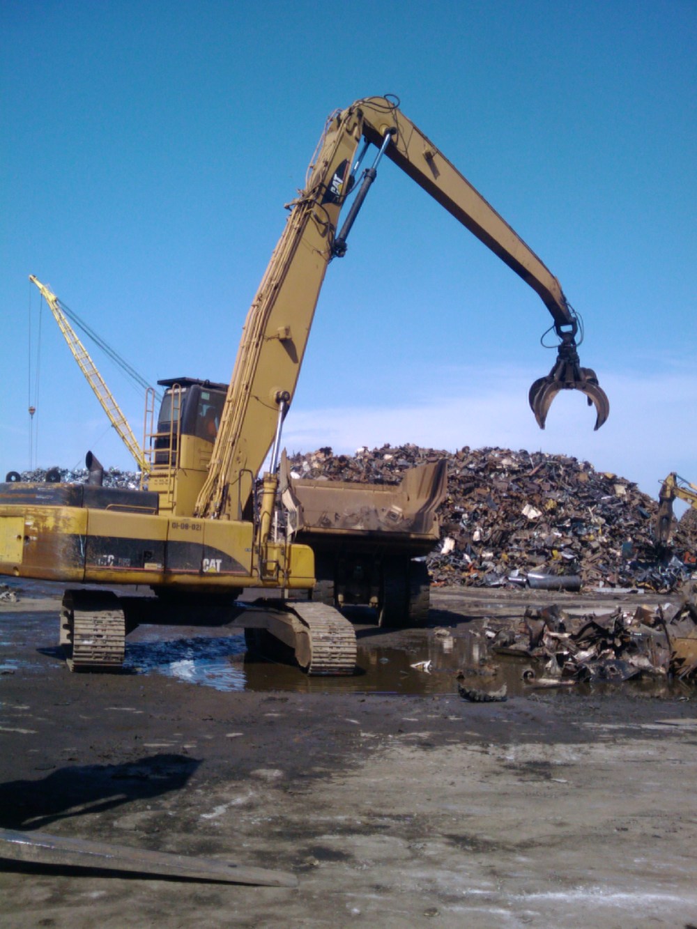 A grappler crane machine in the scrap metal yard
