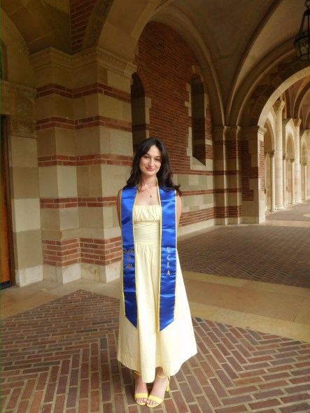 Maya outside of Royce Hall wearing her UCLA class of 2025 graduation stole.