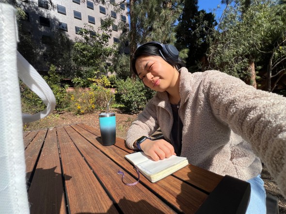 Amy studying outside wearing headphones.