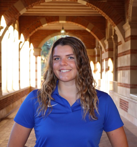 Professional photo of Anna outside of Royce Hall and wearing a blue UCLA polo shirt.