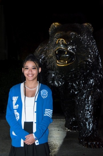 Nay next to the Bruin Bear statue wearing her sorority sweater.