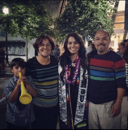 Samuel as a kid blowing a trumpet while celebrating her sister’s graduation from UCLA alongside his parents.