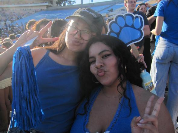 Namuun posing with a friend wearing blue at their first UCLA Football game. 
